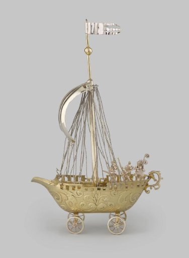 Drinking cup in the shape of a ship on four wheels, rigged with mast and sail, with five soldiers on the aft deck
