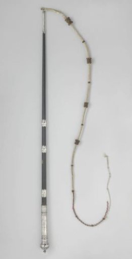 Whip with handle of dark lacquered wood, with a knob of chased silver and a cord of white leather with ornaments of braided leather