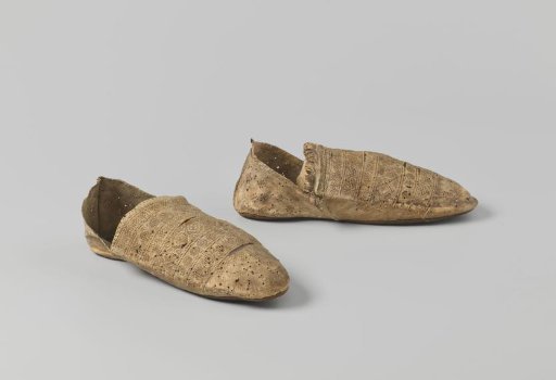 Flat shoe of goat(?) leather with decorated vamp in which rosettes, diamonds and waffle patterns are stamped