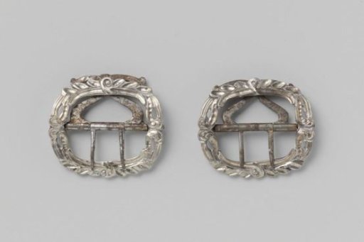 Silver buckle with decorated border and a hinged part with two teeth