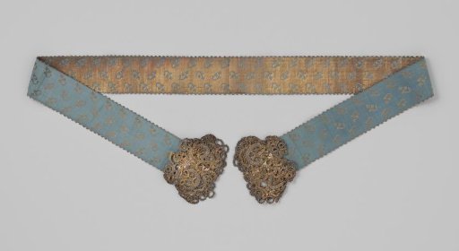 Belt, bridal sash (?), of blue silk and gold thread; on a blue background a scattered pattern of flower branches is applied; both ends are trimmed with passementerie of gold and silver thread