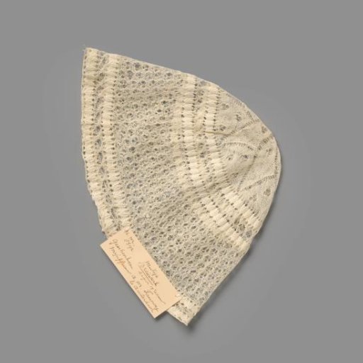 Knitted children's cap with a central flower-star motif, openwork and edges in border stitch
