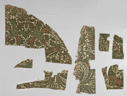 Fragments of green velvet wallpaper with a pattern of vines with leaf and foliage work