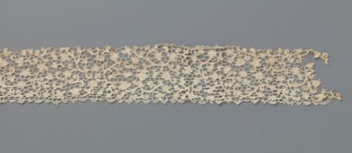 Strip of needle lace with curling vines and various flowers