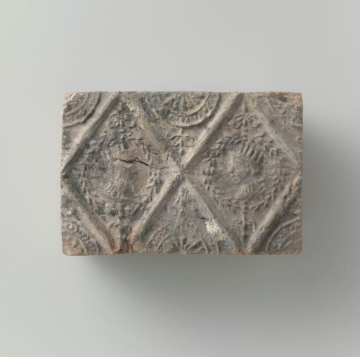 Fireplace stone with a rhomboid decoration containing crowned heads.