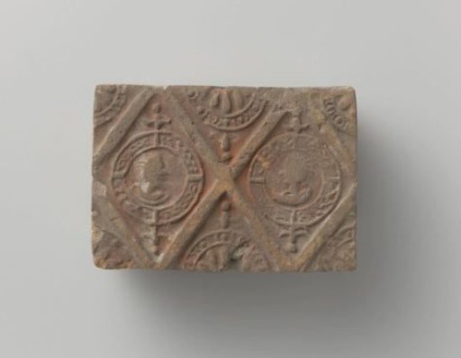 Fireplace with a depiction of a man's and a woman's head in two profiled lozenges