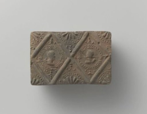 Fireplace with a depiction of a man's and a woman's head in two profiled lozenges
