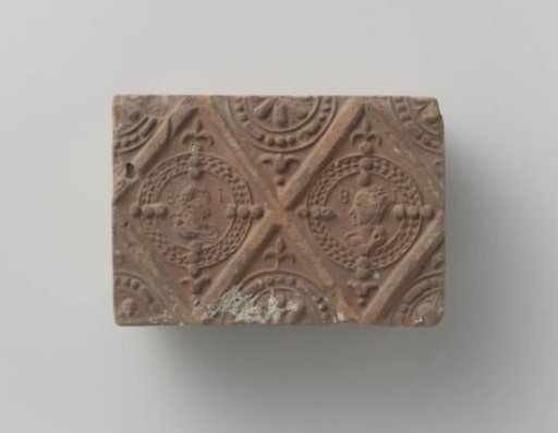 Fireplace of baked clay with a diamond-shaped division with two medallions of a man and a woman