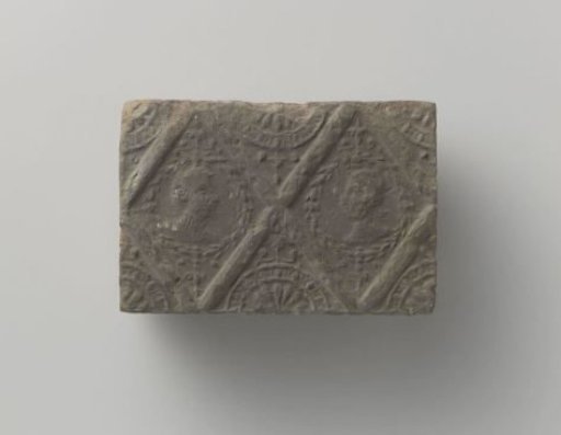 Fireplace with a representation of a man's and a woman's head in two profiled diamonds