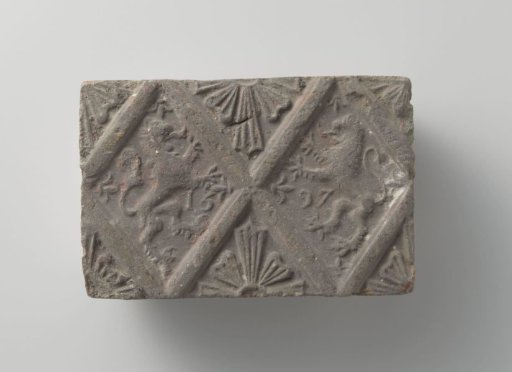 Fireplace of baked clay with a diamond-shaped division, with climbing lions facing each other in the diamonds and diamond-shaped flowers