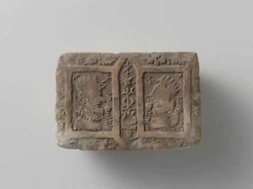 Fireplace of baked clay with a diamond-shaped division, with images of a king and queen surrounded by flowers and fruit