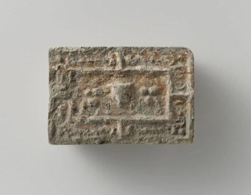 Fireplace stone with a representation of a mask between two fruit festoons