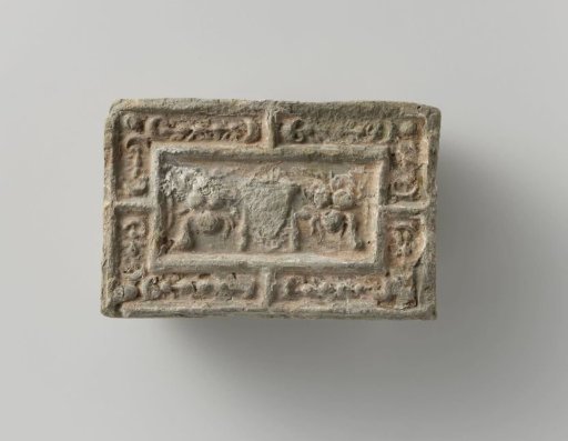 Fireplace stone with a representation of a mask between two fruit festoons