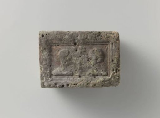 Fireplace with a representation of a male and female head on either side of a vase