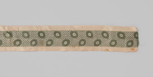 Ribbon or garter of silk with lance effect; along the entire length of the pink ribbon runs a green band with a grid pattern containing daisies