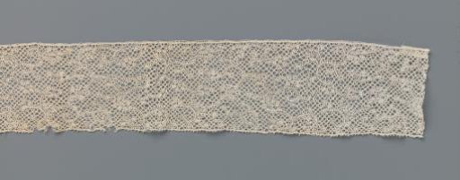 Strip of bobbin lace with tangled pattern of C-shaped twigs with oval knobs
