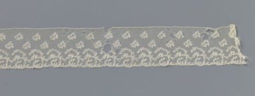 Strip of bobbin lace with whimsical scatter motifs and vine