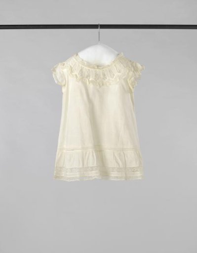 Children's smock of thin white cotton, trimmed with lace along the bodice, sleeve caps, neckline, and hem, with a lace insertion at the bottom of the skirt
