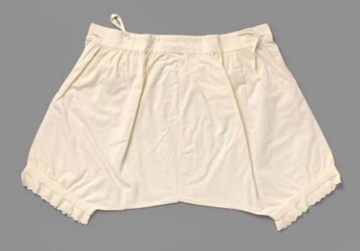 White cotton drawers with legs, decorated with gathering, between which stylised white embroidered leaf scrolls, and a scalloped border with English embroidery