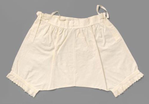 White cotton drawers with legs, decorated with gathering, between which stylised white embroidered leaf scrolls, and a scalloped border with English embroidery