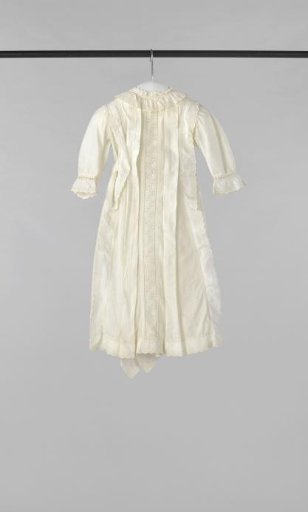 Children's dress with long sleeves, back closure and ribbon sash of white cotton with woven stripes, decorated on the front with two sewn-in pleats, passementerie and English embroidery