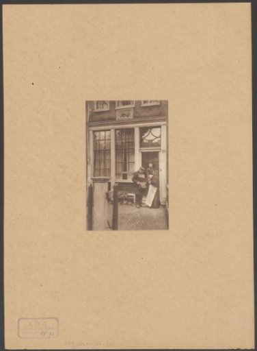 Three people in front of the door of Begijnhof 19 in Amsterdam