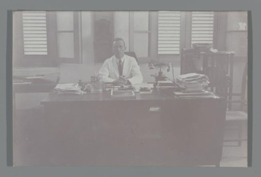 Portrait of a man behind his desk
