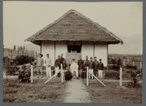 Official with staff in front of a house, 1912