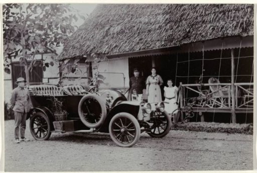 Officer with wife and child and chauffeur by a car