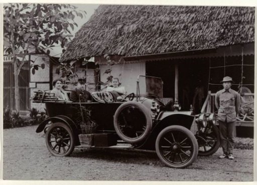 Officer with wife and child and chauffeur by a car