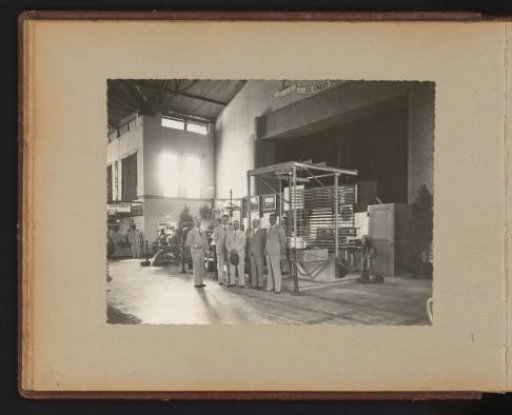 Directors Posing in the Factory Beside a Display of Machines