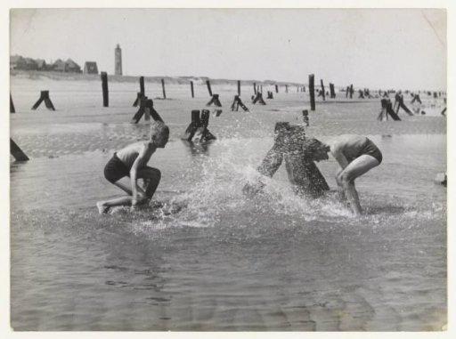 Two boys playing on the beach of Noordwijk in the sea