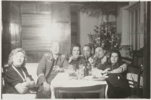Three members of the Wehrmacht and three women around a table