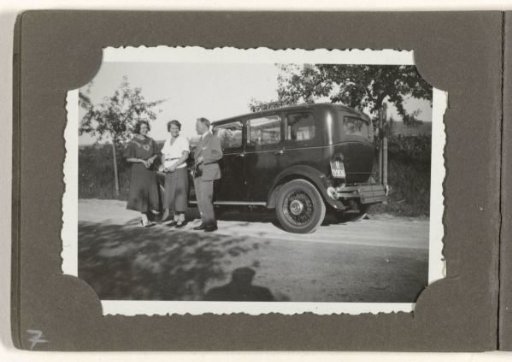 Three people in front of a car