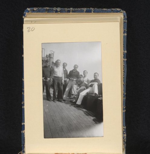 Sailors on board their ship with a dog