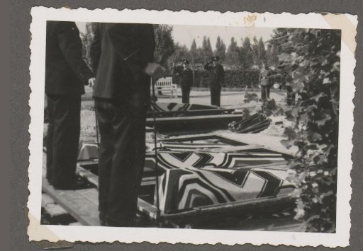 Burial of three fallen soldiers with swastika flags over the coffins