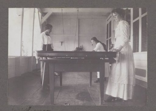 Three women playing billiards