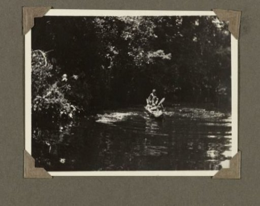 Villagers in a Canoe on a River in Suriname