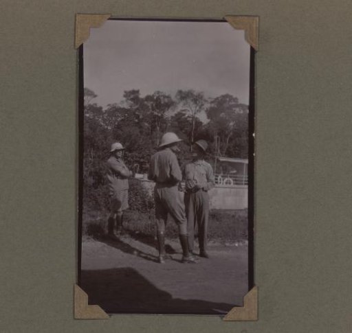 Three men by a river boat