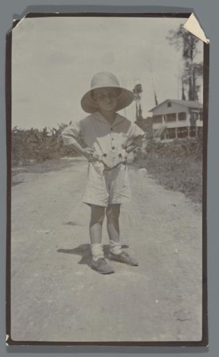 Boy with a tropical helmet on a path