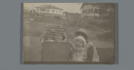 Childcare nurse with a pram and two children