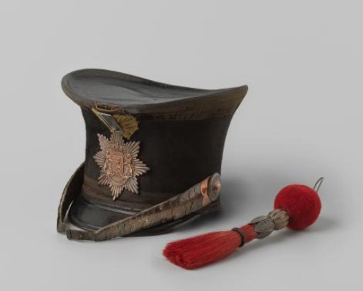 Shako of black beaver, with flap and bottom of black leather, and shako plate bearing the Coat of Arms of the Realm and the motto JE MAINTIENDRAI