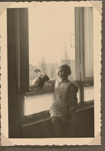 Isabel Wachenheimer with plush animals by an open window, June 1934