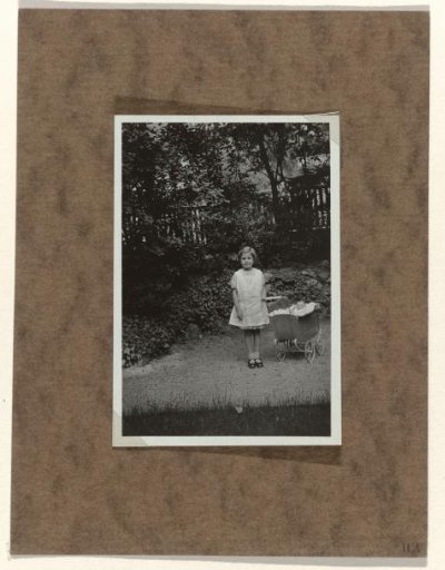 Isabel Wachenheimer in a garden with a pram containing a doll