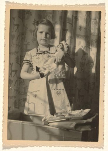 Isabel Wachenheimer in front of a pram and holding a doll in her arms, April-May 1935, Stuttgart