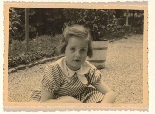 Isabel Wachenheimer in a striped dress in front of a row of houses, April-May 1935
