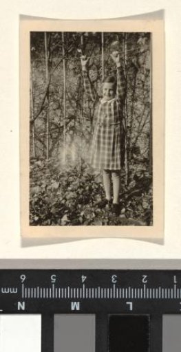 Isabel Wachenheimer with outstretched arms and hands on a rope in front of a pond, October 1936