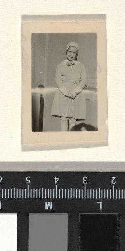 Isabel Wachenheimer wearing a cap and a necklace of buns in front of a wall