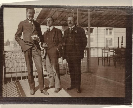 Eugen Wachenheimer as a young man with two unknown men outside under an awning, 1906-1926