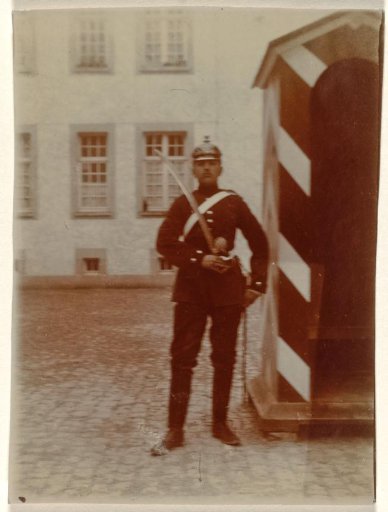 Cousin of the Wachenheimer family as a corporal (Gefreiter) with a saber and Pickelhaube during barracks guard duty in front of a guardhouse, April 1910